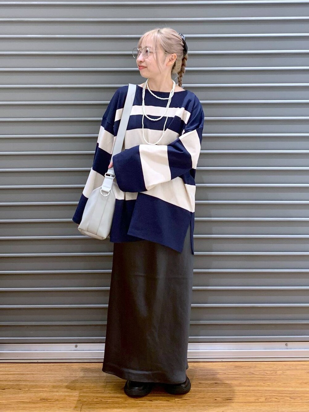 グレー系のスカート、グレー系のショルダーバッグ、ブラック系のスニーカーを着用したレディースの秋コーディネートの4枚目の写真