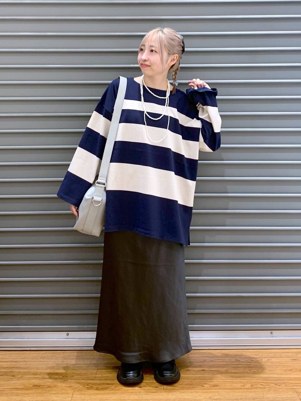 グレー系のスカート、グレー系のショルダーバッグ、ブラック系のスニーカーを着用したレディースの秋コーディネートの5枚目の写真