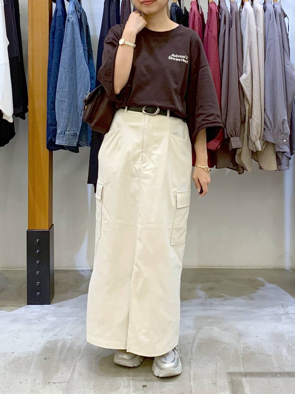 ホワイト系のスカート、ブラウン系のショルダーバッグ、ブラウン系のTシャツ/カットソーを着用したレディースの秋コーディネートの5枚目の写真