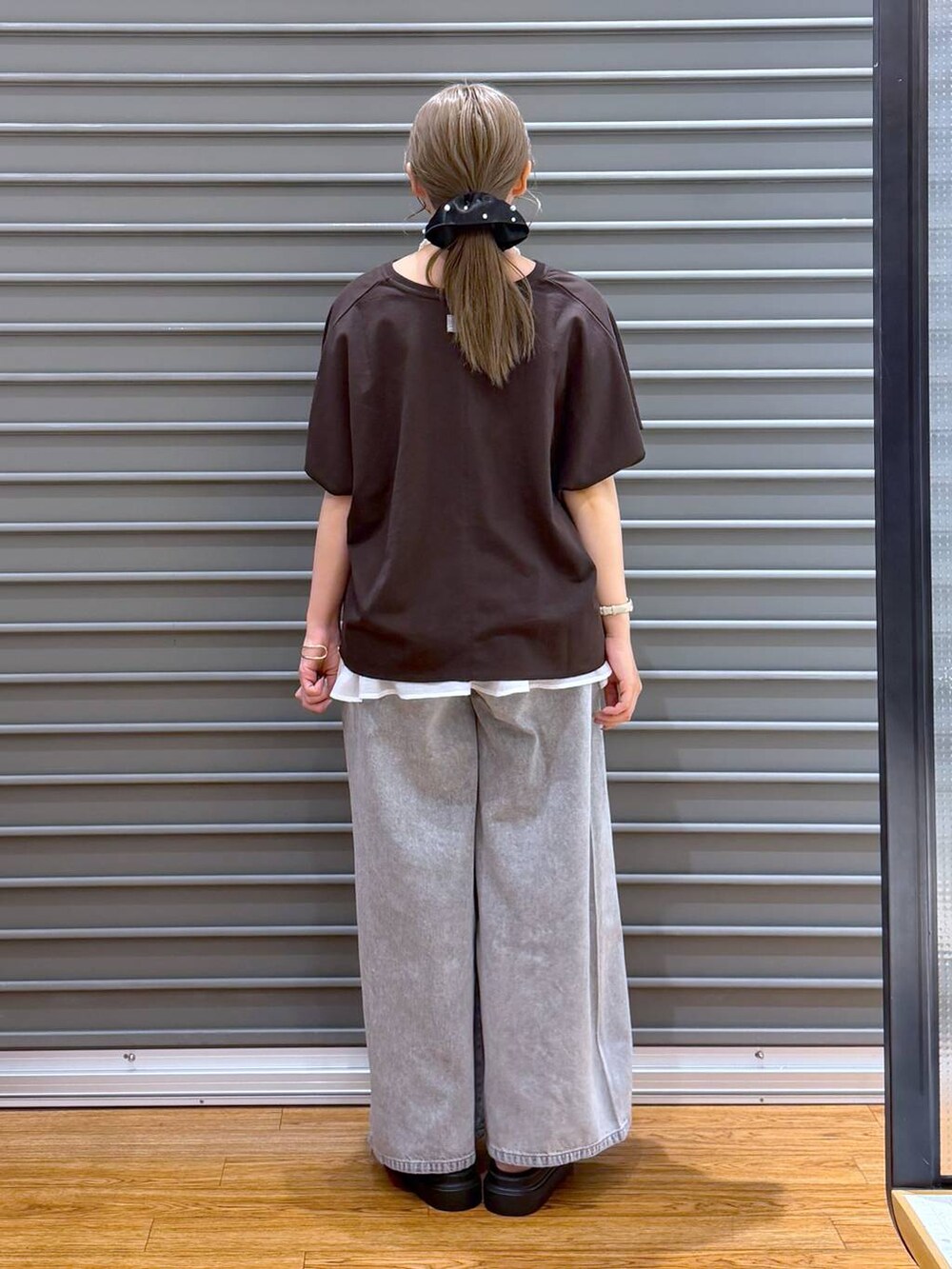 グレー系のショルダーバッグ、グレー系のデニムパンツ、その他のサンダルを着用したレディースの夏コーディネートの2枚目の写真