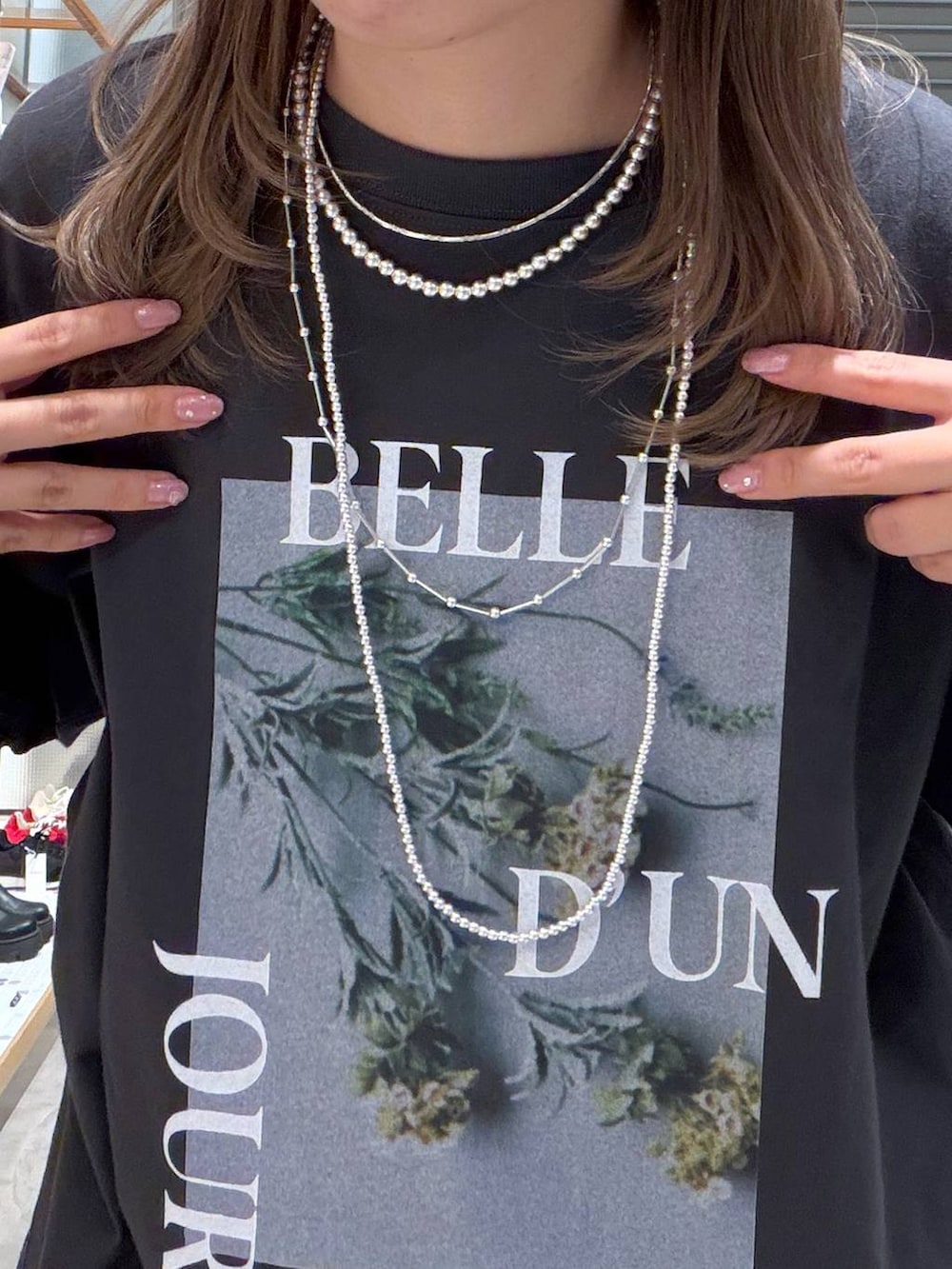 グレー系のTシャツ/カットソー、ブルー系のデニムパンツ、シルバー系のネックレスを着用したレディースの春コーディネートの5枚目の写真