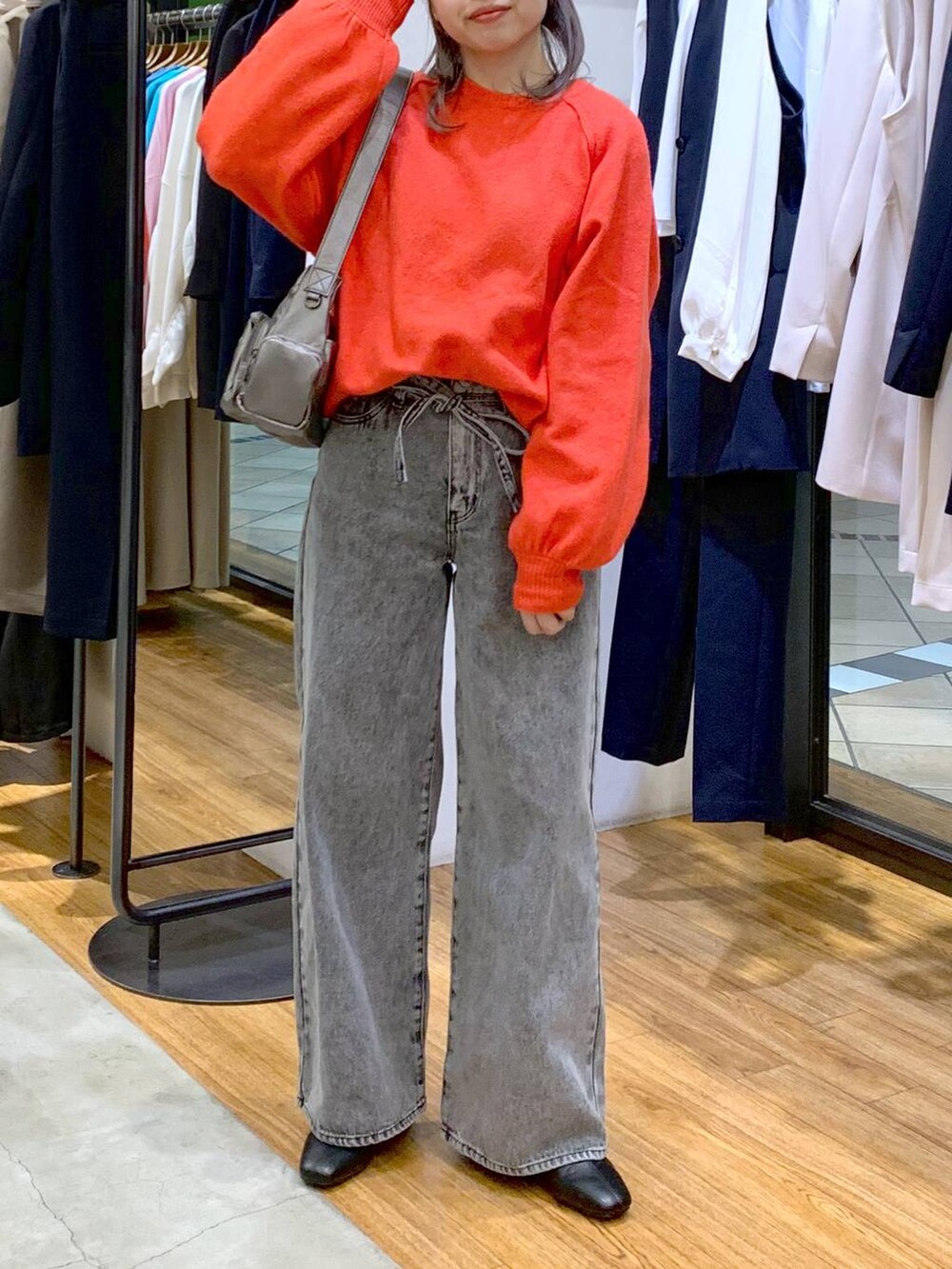 レッド系のニット/セーター、ブラック系のブーツ、その他のショルダーバッグを着用したレディースの冬コーディネートの3枚目の写真