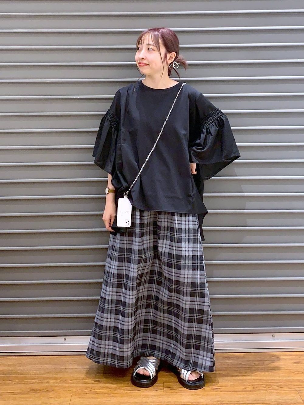ブラック系のTシャツ/カットソー、シルバー系のサンダル、ホワイト系のスカートを着用したレディースの夏コーディネートの3枚目の写真