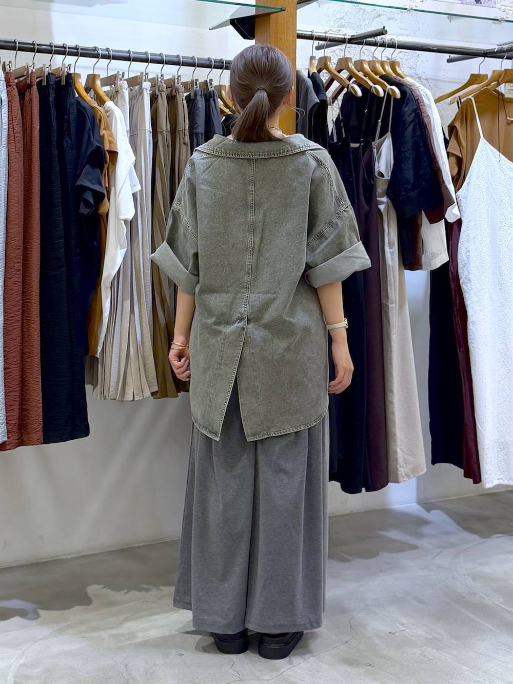 グレー系のその他パンツ、ホワイト系のサンダル、グリーン系のシャツ/ブラウスを着用したレディースの春コーディネートの2枚目の写真