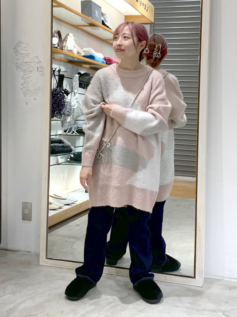 ブルー系のデニムパンツ、ブラック系のその他シューズ、ピンク系のチュニックを着用したレディースの秋コーディネートの4枚目の写真