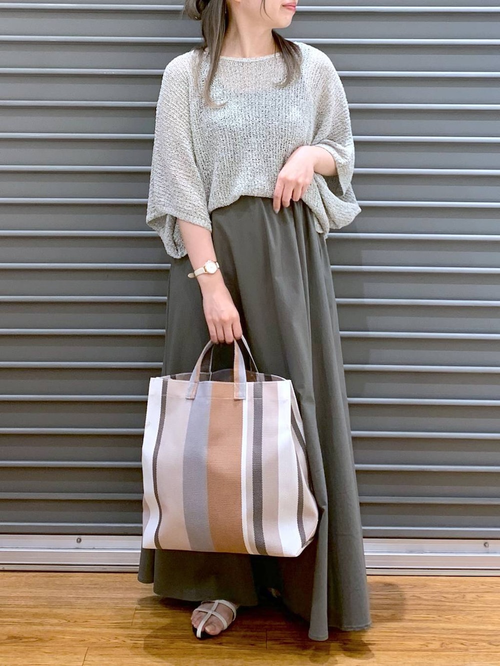 ベージュ系のニット/セーター、ホワイト系のサンダル、ベージュ系のトートバッグを着用したレディースの夏コーディネートの6枚目の写真