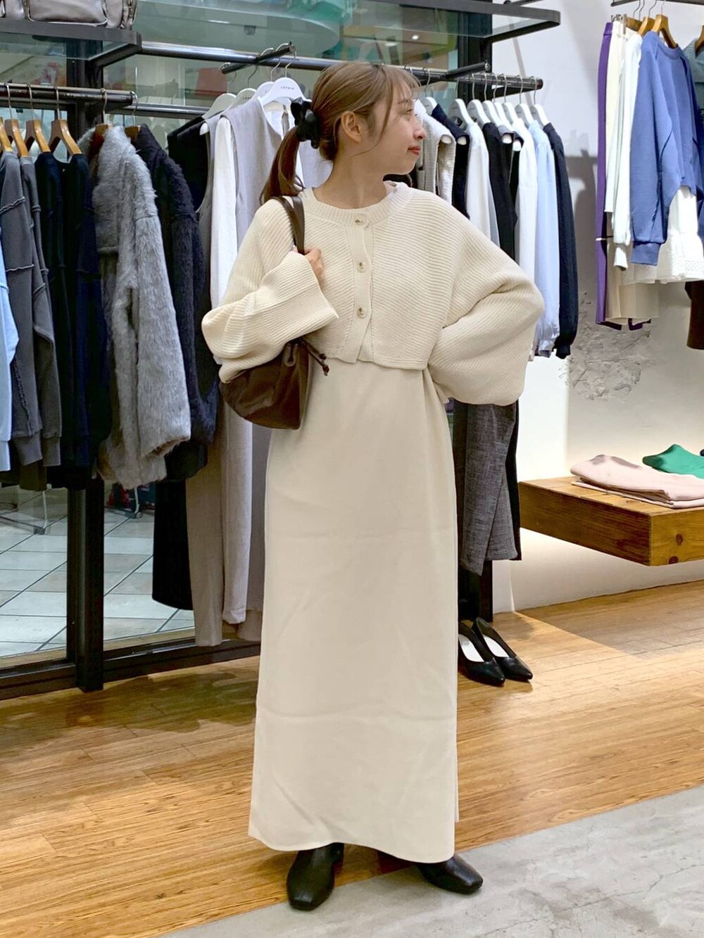 ブラック系のブーツ、ホワイト系のワンピース、ブラウン系のショルダーバッグを着用したレディースの冬コーディネートの5枚目の写真