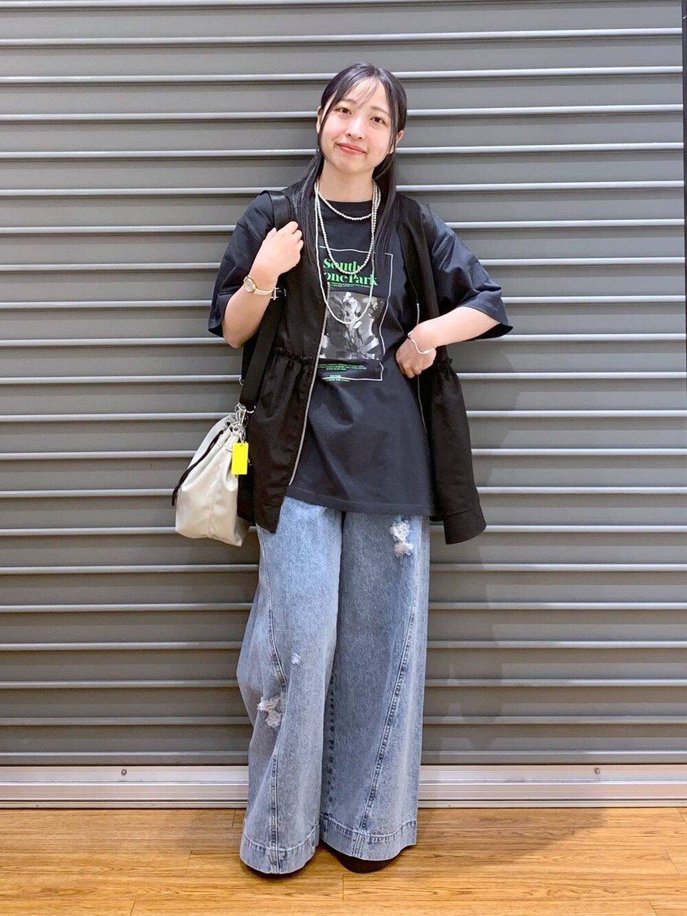 シルバー系のサンダル、ブルー系のデニムパンツ、ブラック系のベストを着用したレディースの夏コーディネートの5枚目の写真