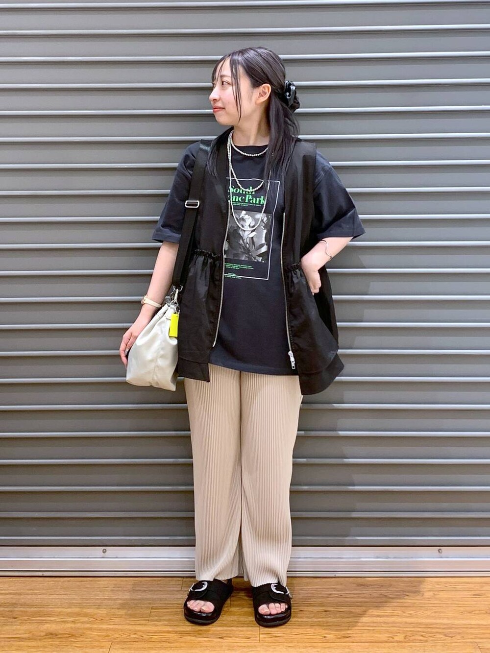 ブラック系のベスト、ベージュ系のその他パンツ、ブラック系のサンダルを着用したレディースの夏コーディネートの4枚目の写真