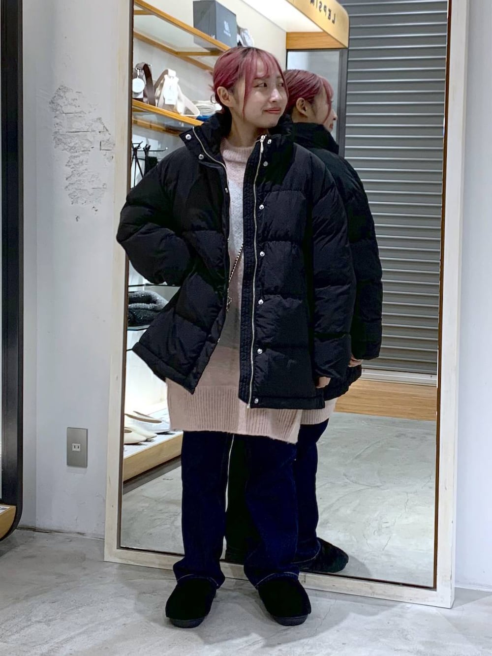 ブルー系のデニムパンツ、ブラック系のダウンジャケット/コート、ブラック系のその他シューズを着用したレディースの冬コーディネートの6枚目の写真