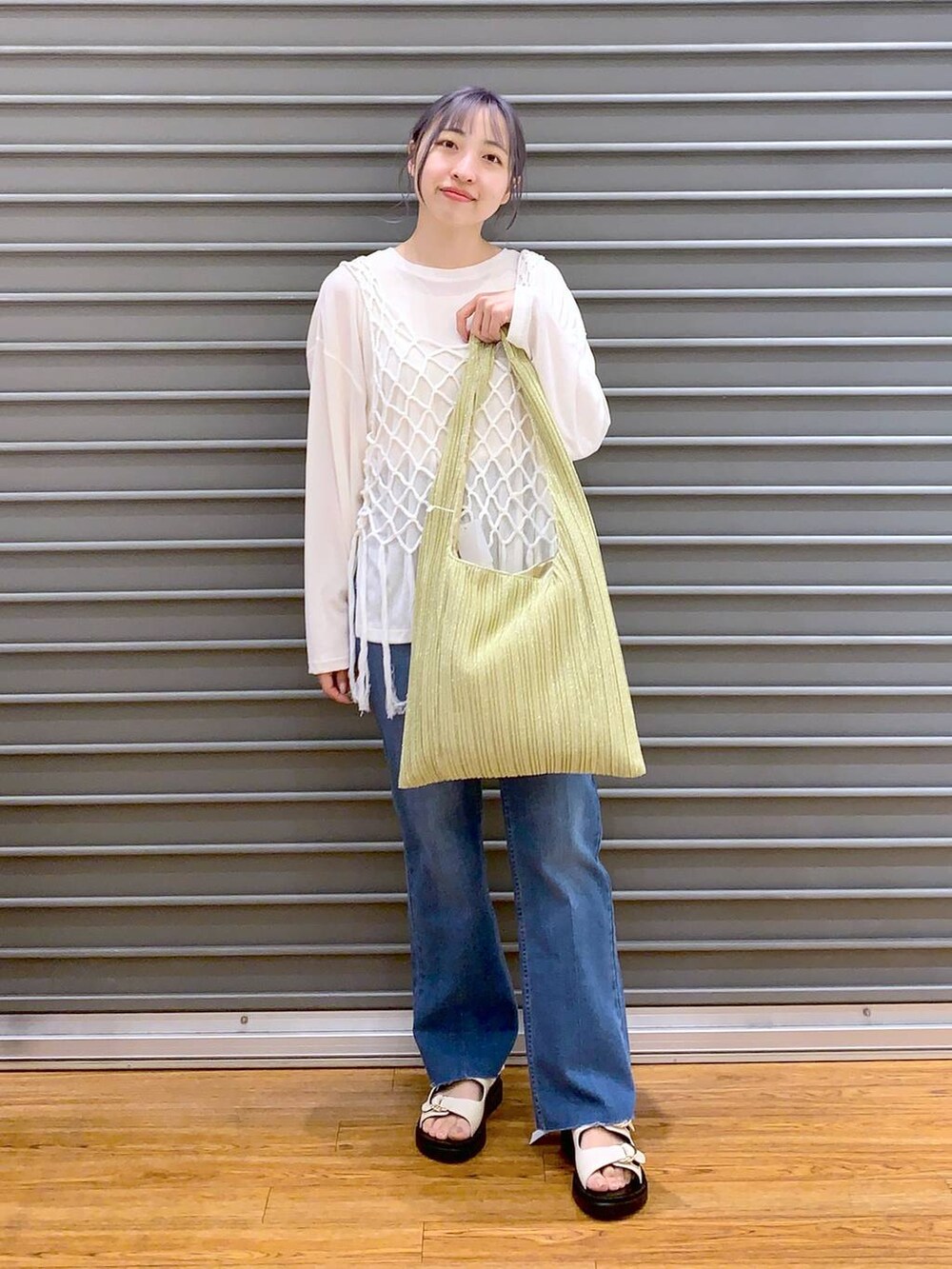 ホワイト系のTシャツ/カットソー、ホワイト系のベスト、ブルー系のデニムパンツを着用したレディースの春コーディネートの4枚目の写真