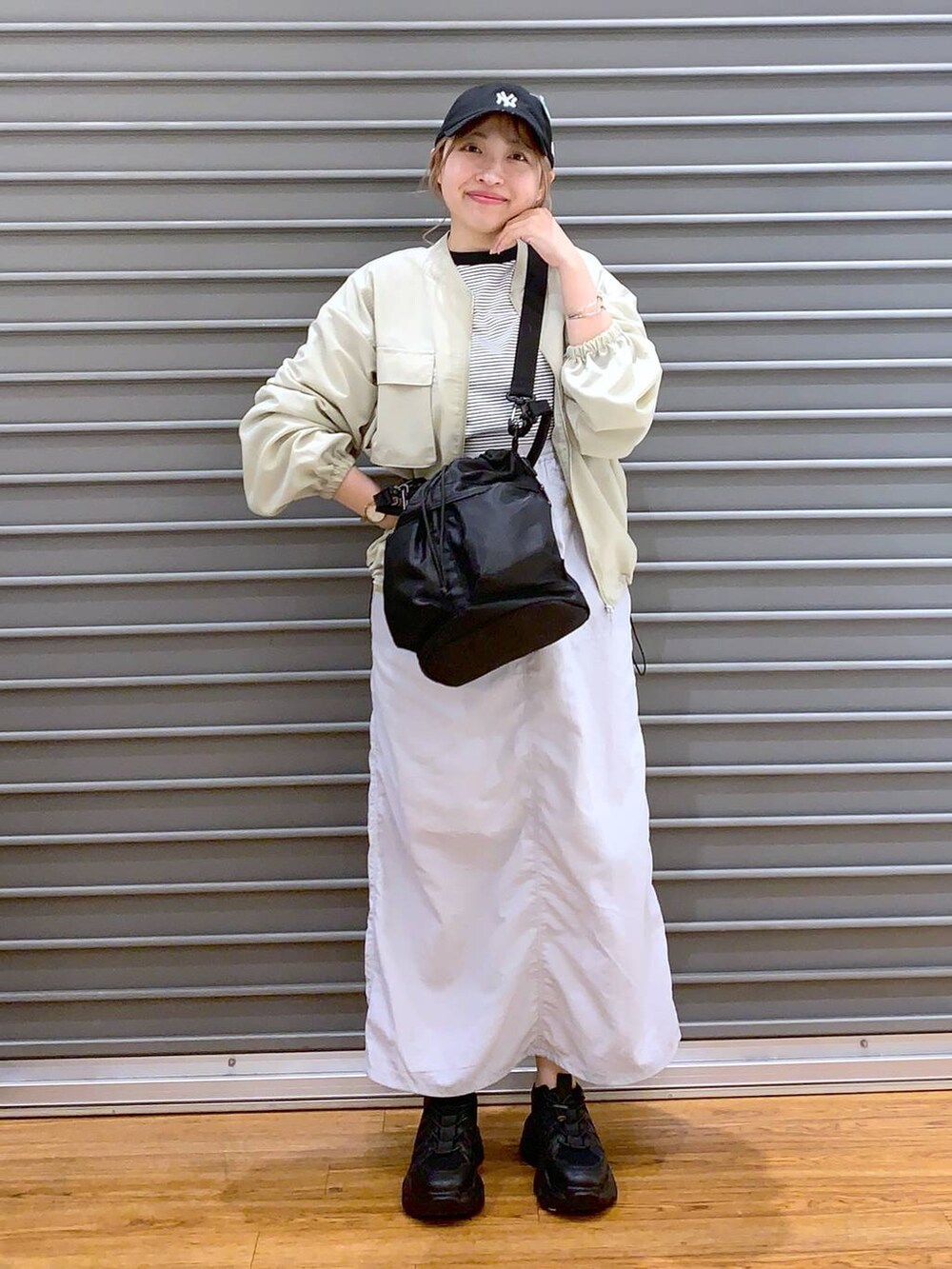 ブラック系のスニーカー、グレー系のTシャツ/カットソー、グレー系のスカートを着用したレディースの春コーディネートの4枚目の写真