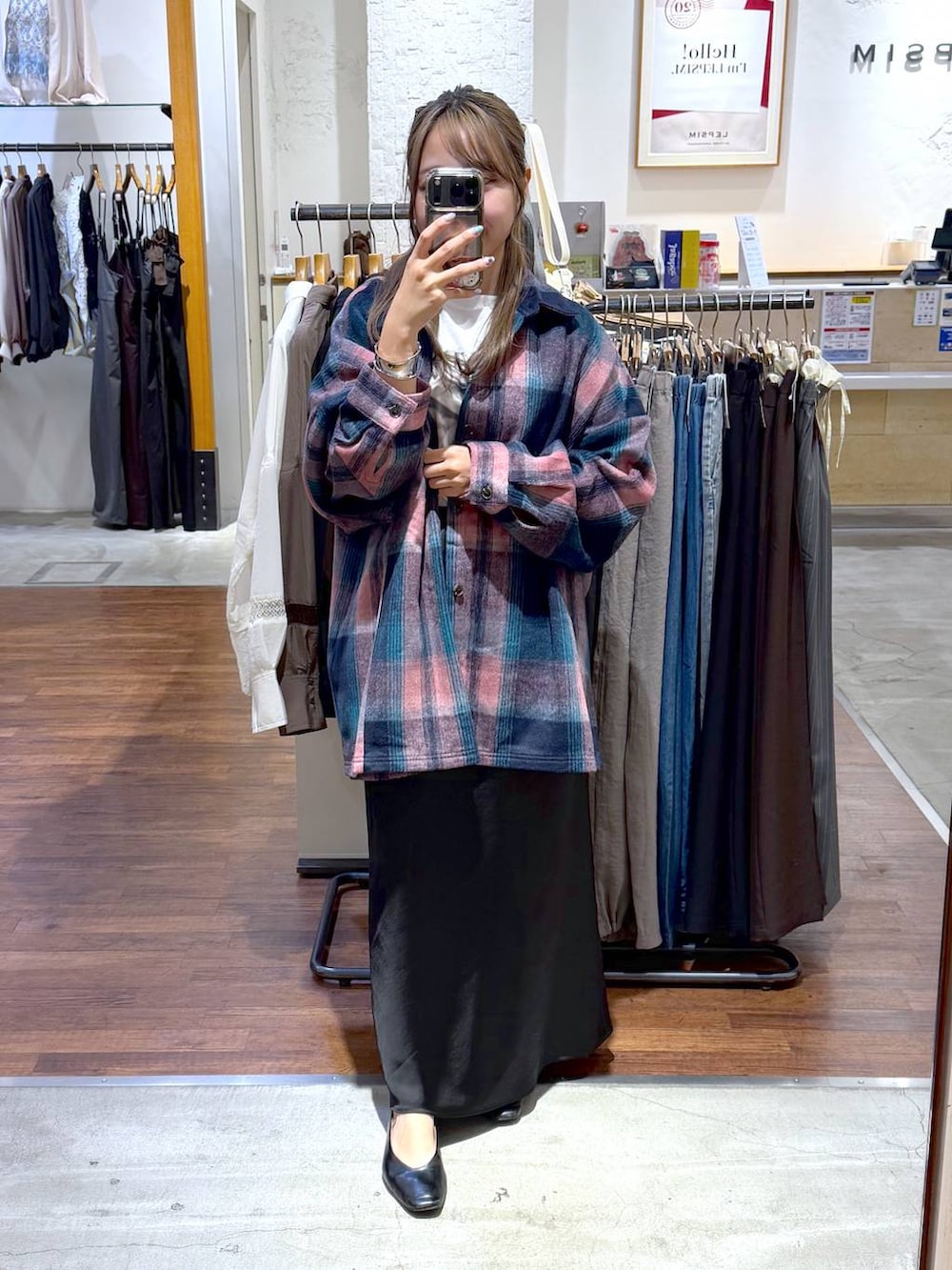 ブラック系のスカート、ホワイト系のTシャツ/カットソー、ブラック系のパンプスを着用したレディースの秋コーディネートの4枚目の写真
