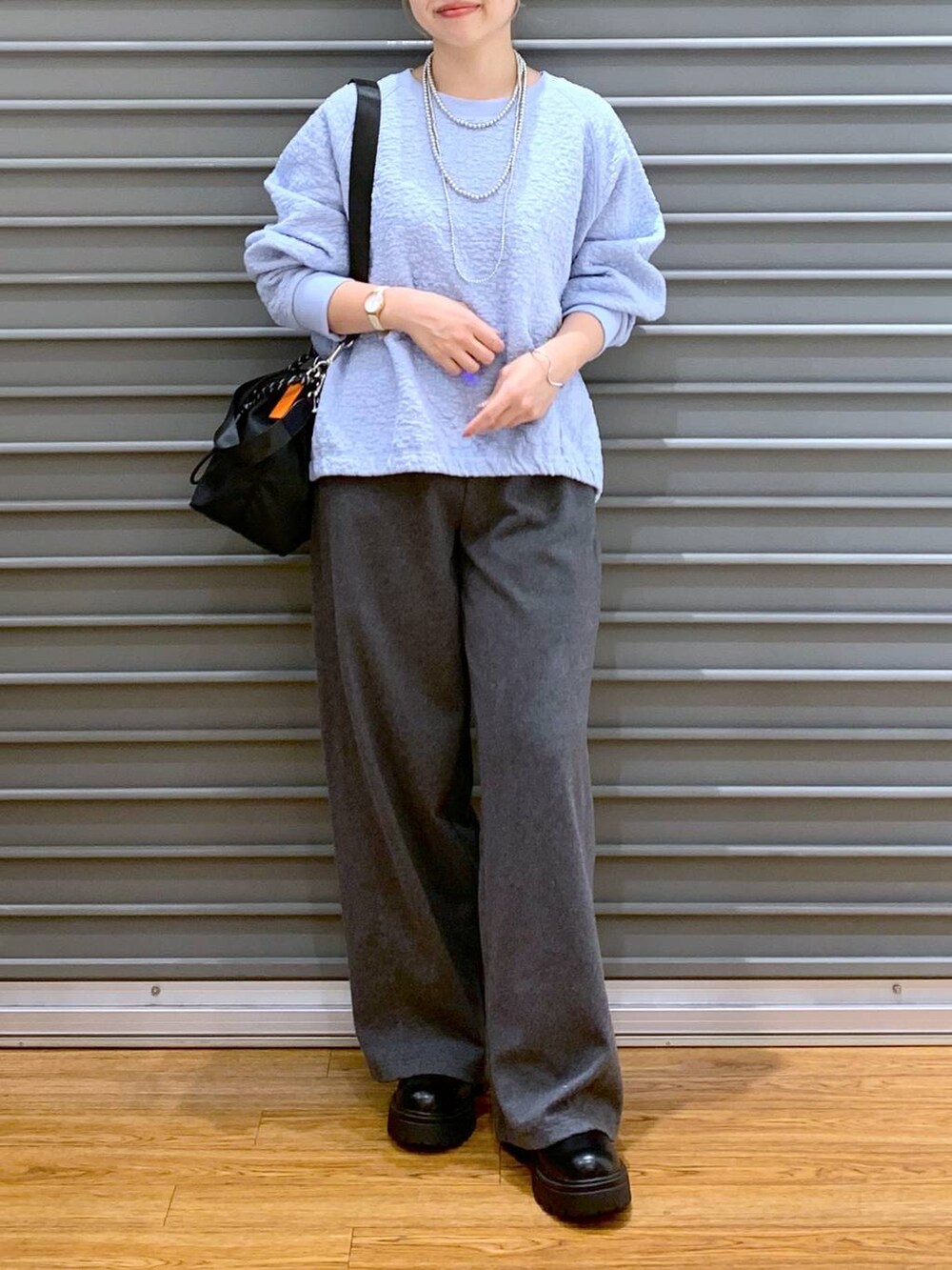 ブラック系のショルダーバッグ、グレー系のその他パンツ、ブラック系のブーツを着用したレディースの秋コーディネートの7枚目の写真