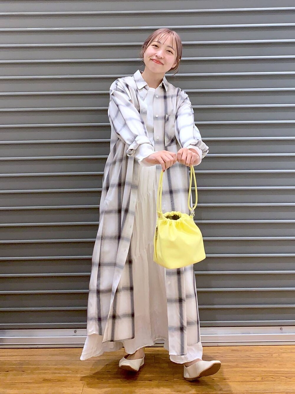 イエロー系のショルダーバッグ、ホワイト系のパンプス、ホワイト系のTシャツ/カットソーを着用したレディースの春コーディネートの5枚目の写真