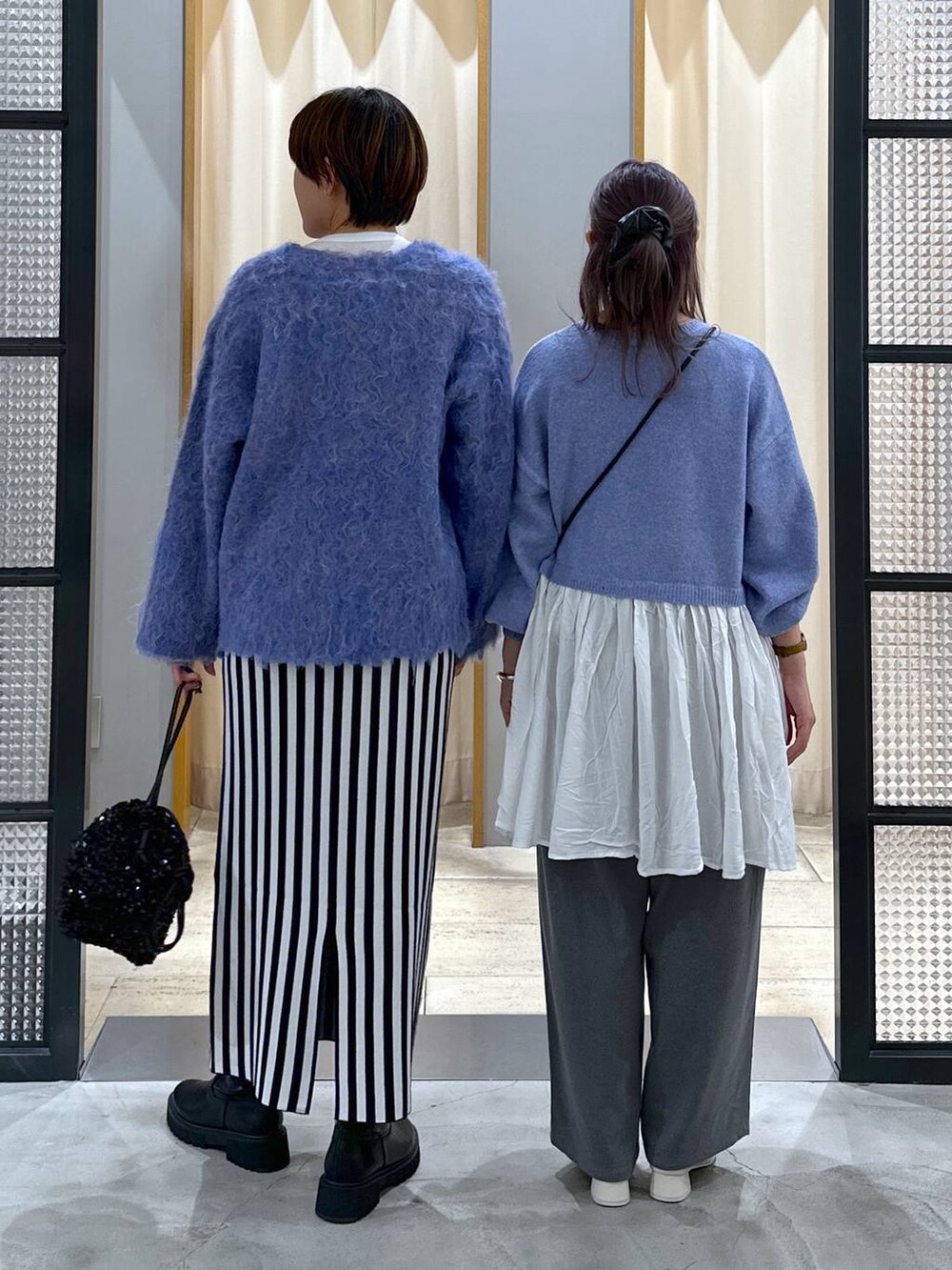 ブラック系のブーツ、ブラック系のショルダーバッグ、ブルー系のショルダーバッグを着用したレディースの秋コーディネートの2枚目の写真