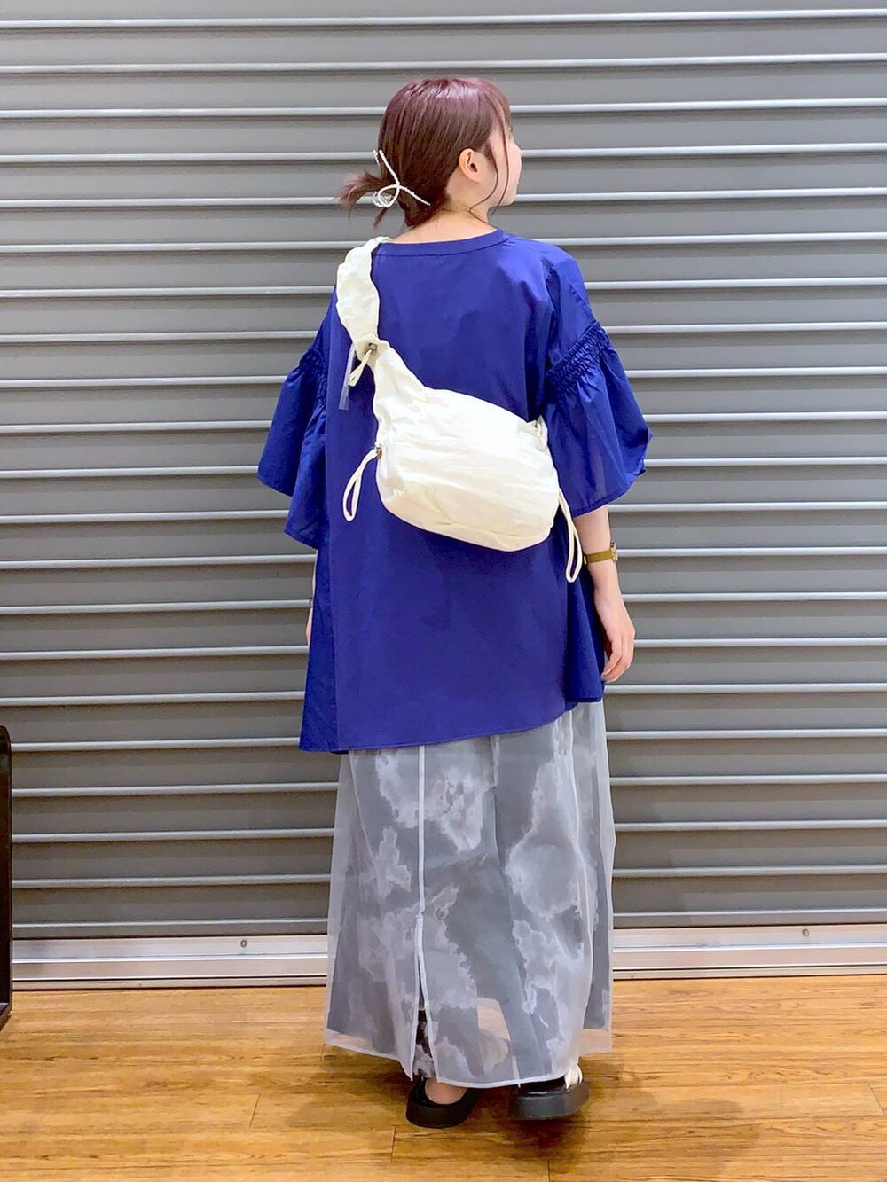 ブルー系のTシャツ/カットソー、ホワイト系のサンダル、ホワイト系のショルダーバッグを着用したレディースの夏コーディネートの2枚目の写真