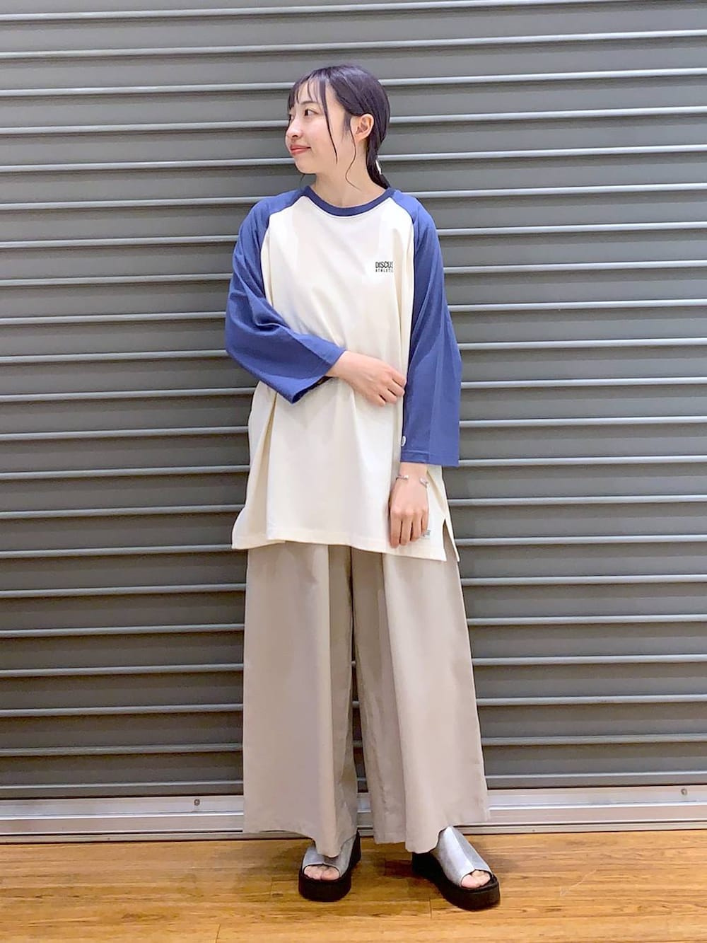ブルー系のTシャツ/カットソー、ベージュ系のその他パンツ、ブラック系のショルダーバッグを着用したレディースの春コーディネートの5枚目の写真