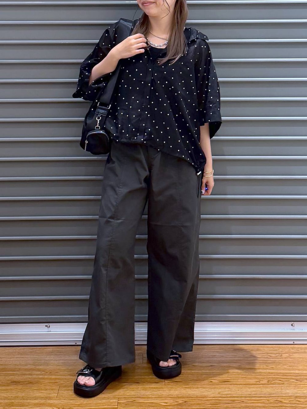 ブラック系のシャツ/ブラウス、グレー系のその他パンツ、ブラック系のサンダルを着用したレディースの夏コーディネートの5枚目の写真