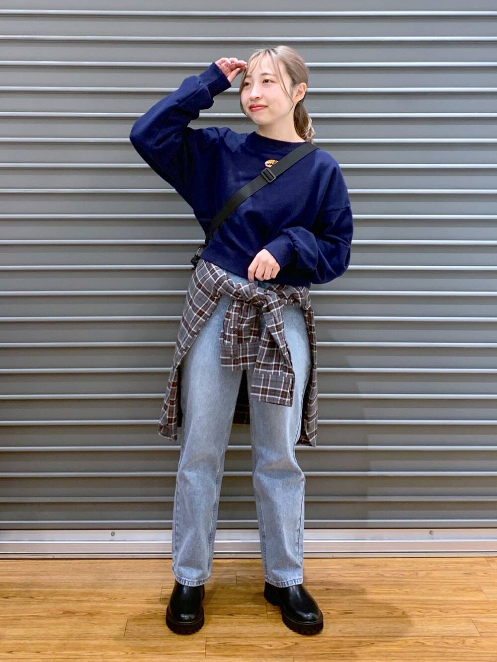 ブラック系のショルダーバッグ、ブルー系のデニムパンツ、ブラック系のブーツを着用したレディースの冬コーディネートの6枚目の写真