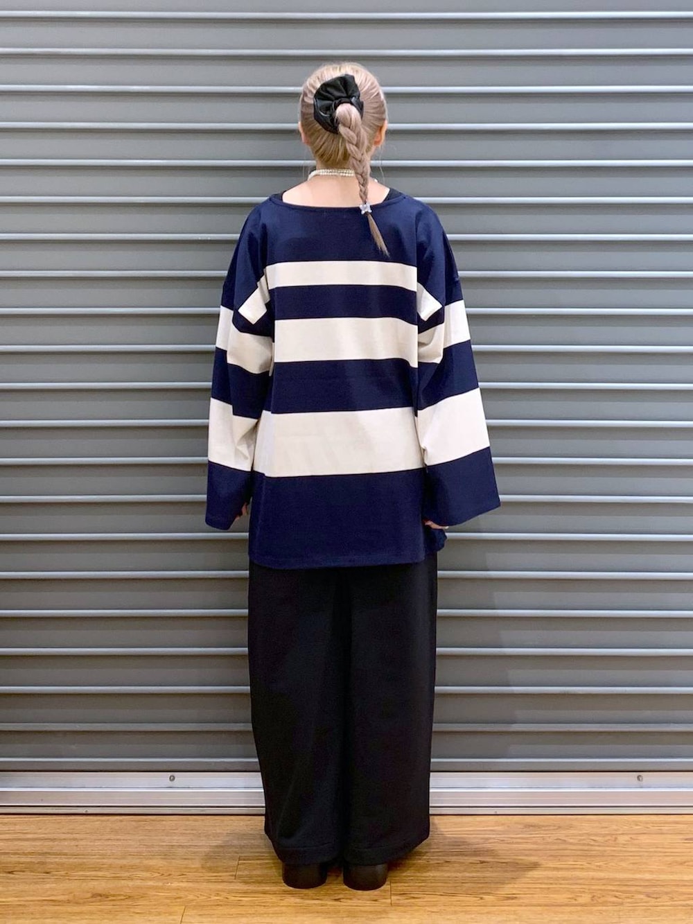 ブラック系のスウェットパンツ、ブラック系のサンダル、ブルー系のTシャツ/カットソーを着用したレディースの秋コーディネートの2枚目の写真