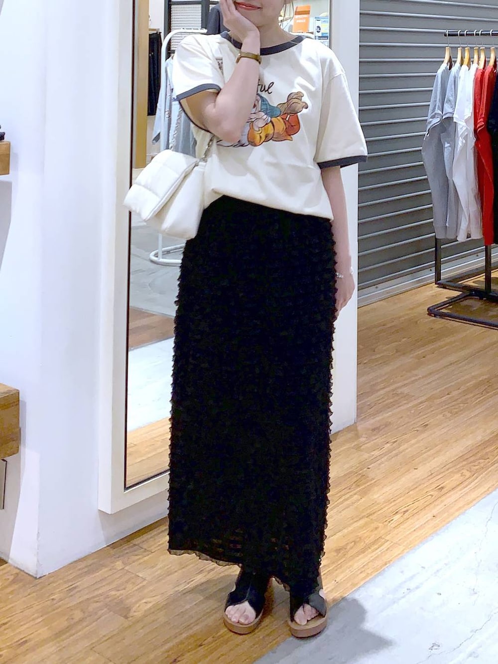 ホワイト系のショルダーバッグ、ブラック系のスカート、ブラック系のサンダルを着用したレディースの夏コーディネートの5枚目の写真