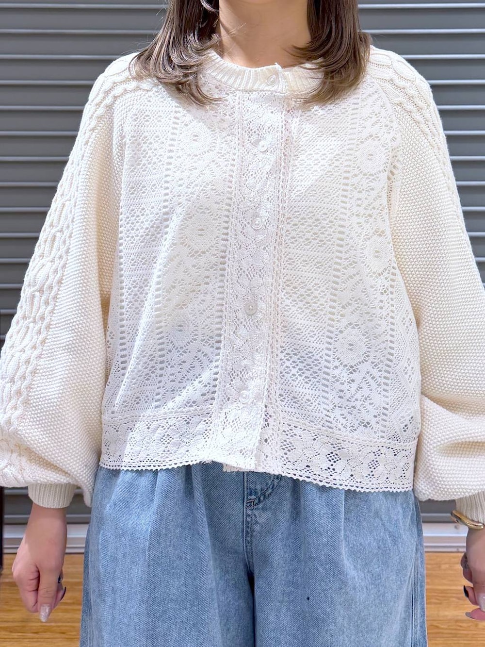 ブラック系のサンダル、ブルー系のデニムパンツ、ブラウン系のボストンバッグを着用したレディースの春コーディネートの4枚目の写真