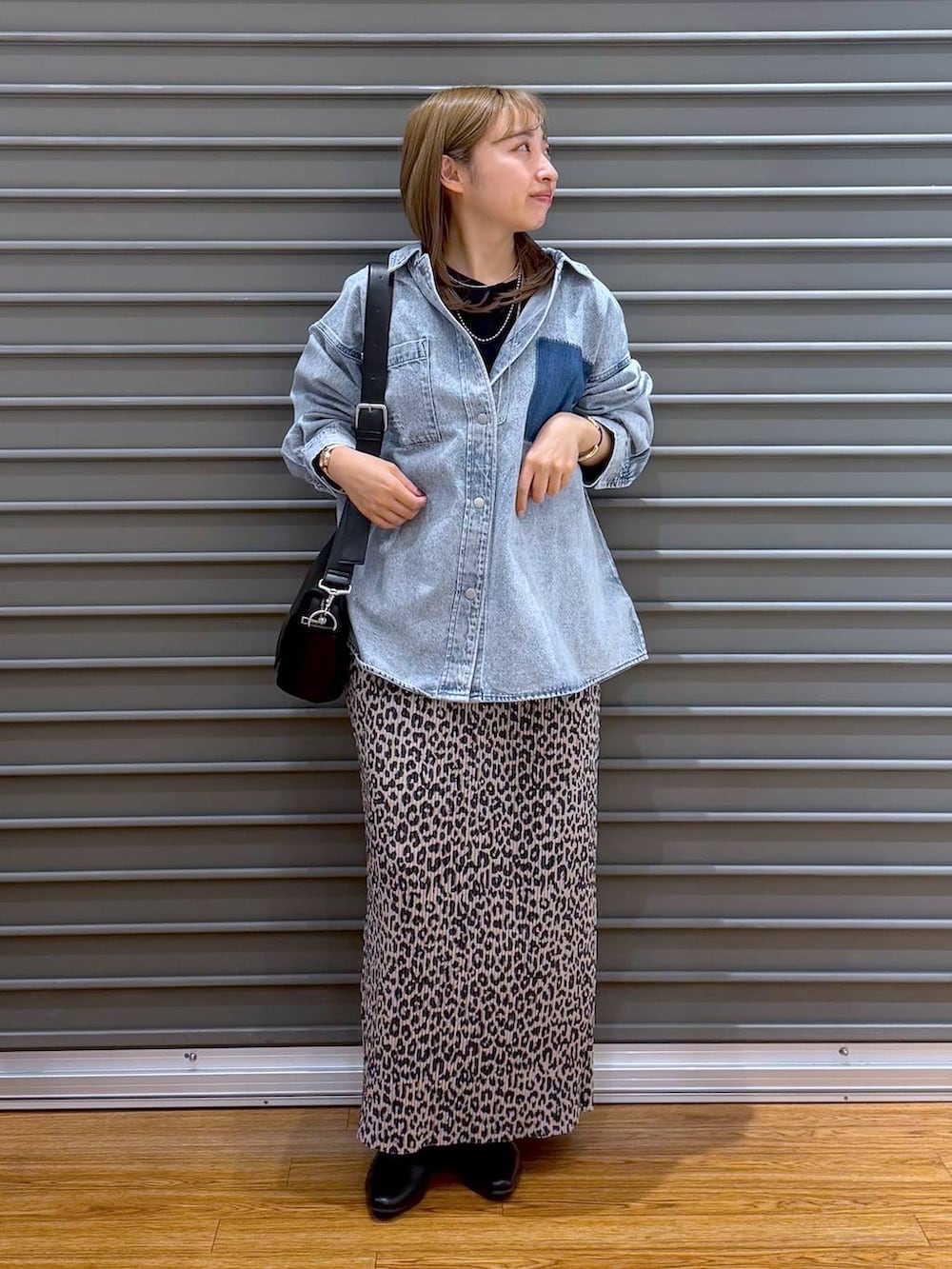 ブラック系のショルダーバッグ、ブルー系のシャツ/ブラウス、ブラック系のパンプスを着用したレディースの春コーディネートの4枚目の写真