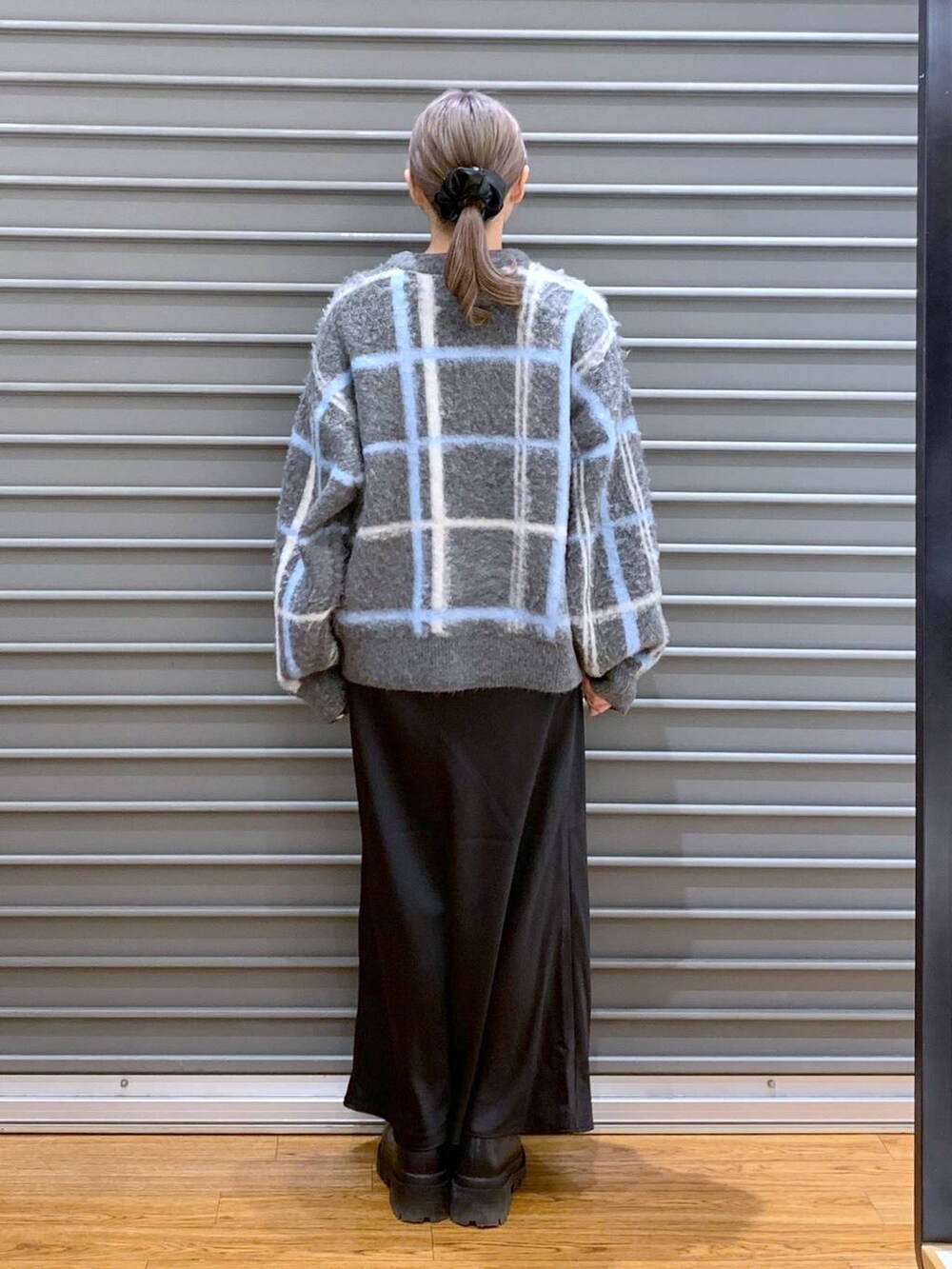 ブラック系のスカート、ブラック系のブーツ、ブラック系のショルダーバッグを着用したレディースの冬コーディネートの2枚目の写真