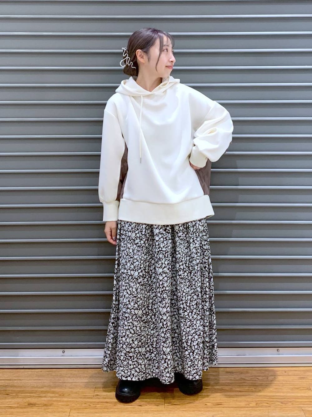 ホワイト系のショルダーバッグ、ブラック系のブーツ、ホワイト系のパーカーを着用したレディースの冬コーディネートの4枚目の写真