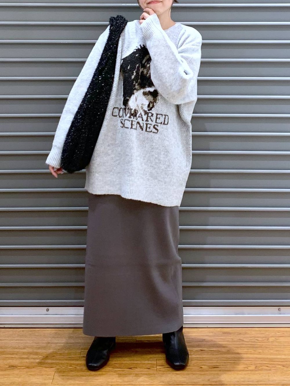 ブラック系のショルダーバッグ、グレー系のスカート、ブラック系のブーツを着用したレディースの冬コーディネートの8枚目の写真