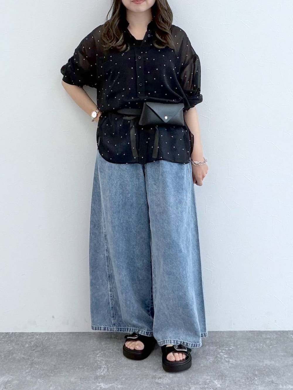 ブラック系のサンダル、ブルー系のデニムパンツ、ブラック系のベルトを着用したレディースの秋コーディネートの3枚目の写真
