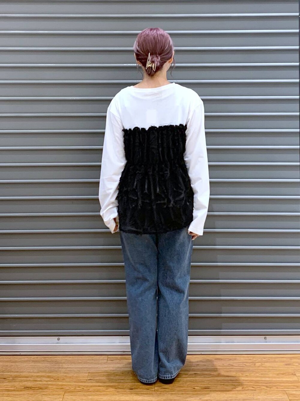 シルバー系のショルダーバッグ、ブルー系のデニムパンツ、ブラック系のバレエシューズを着用したレディースの秋コーディネートの2枚目の写真