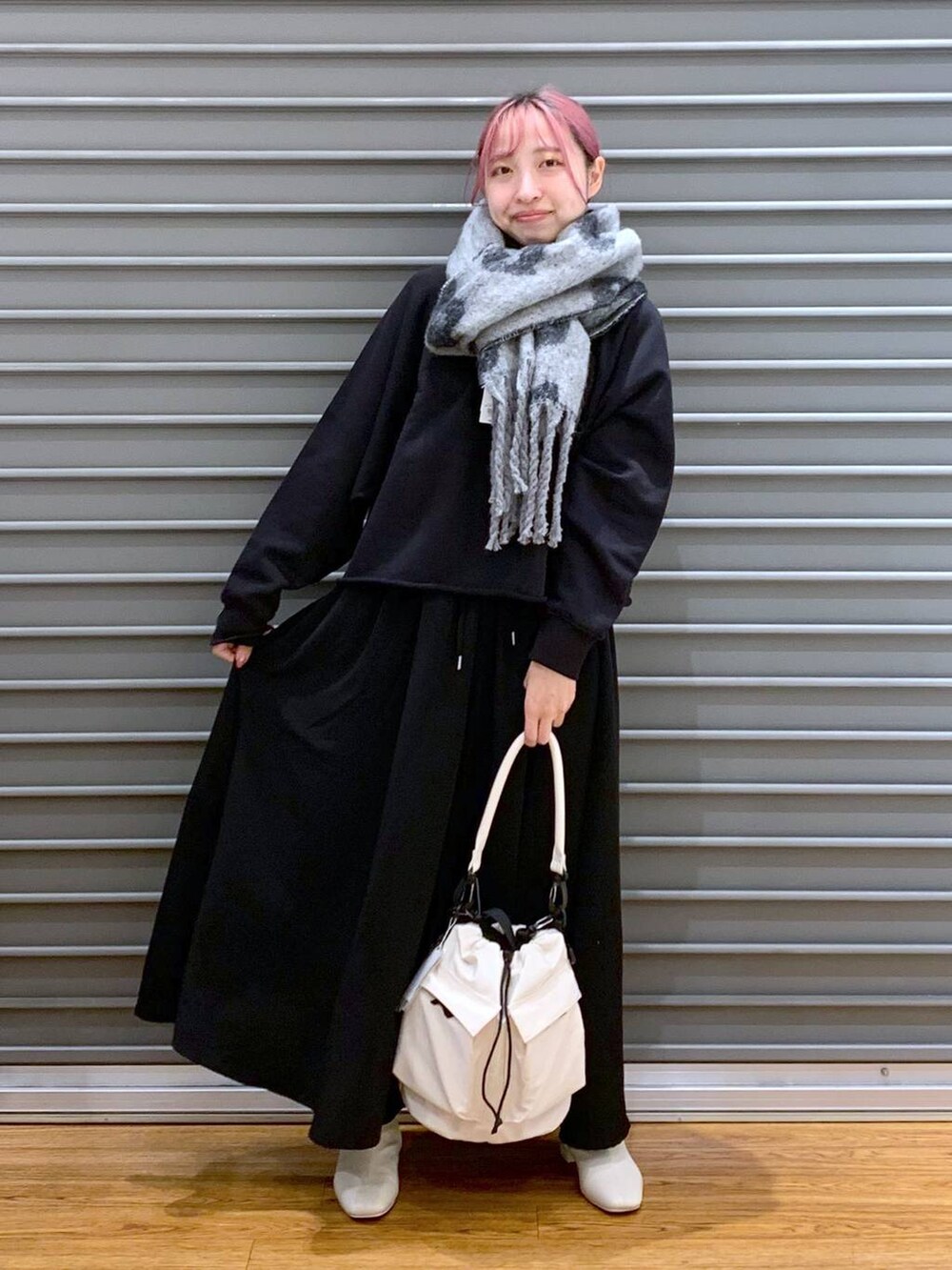 ホワイト系のショルダーバッグ、ホワイト系のブーツ、ブラック系のその他パンツを着用したレディースの秋コーディネートの6枚目の写真