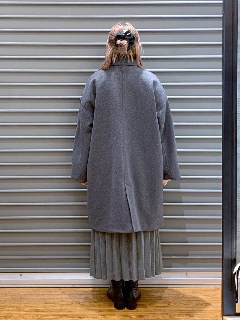 グレー系のその他アウター、ブラック系のブーツ、グレー系のワンピースを着用したレディースの冬コーディネートの2枚目の写真