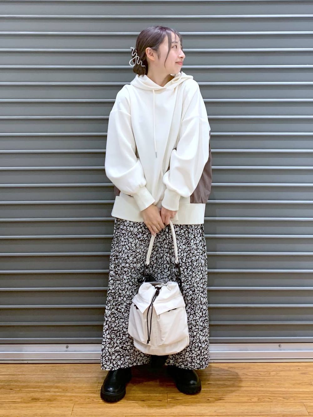 ホワイト系のショルダーバッグ、ブラック系のブーツ、ホワイト系のパーカーを着用したレディースの冬コーディネートの7枚目の写真