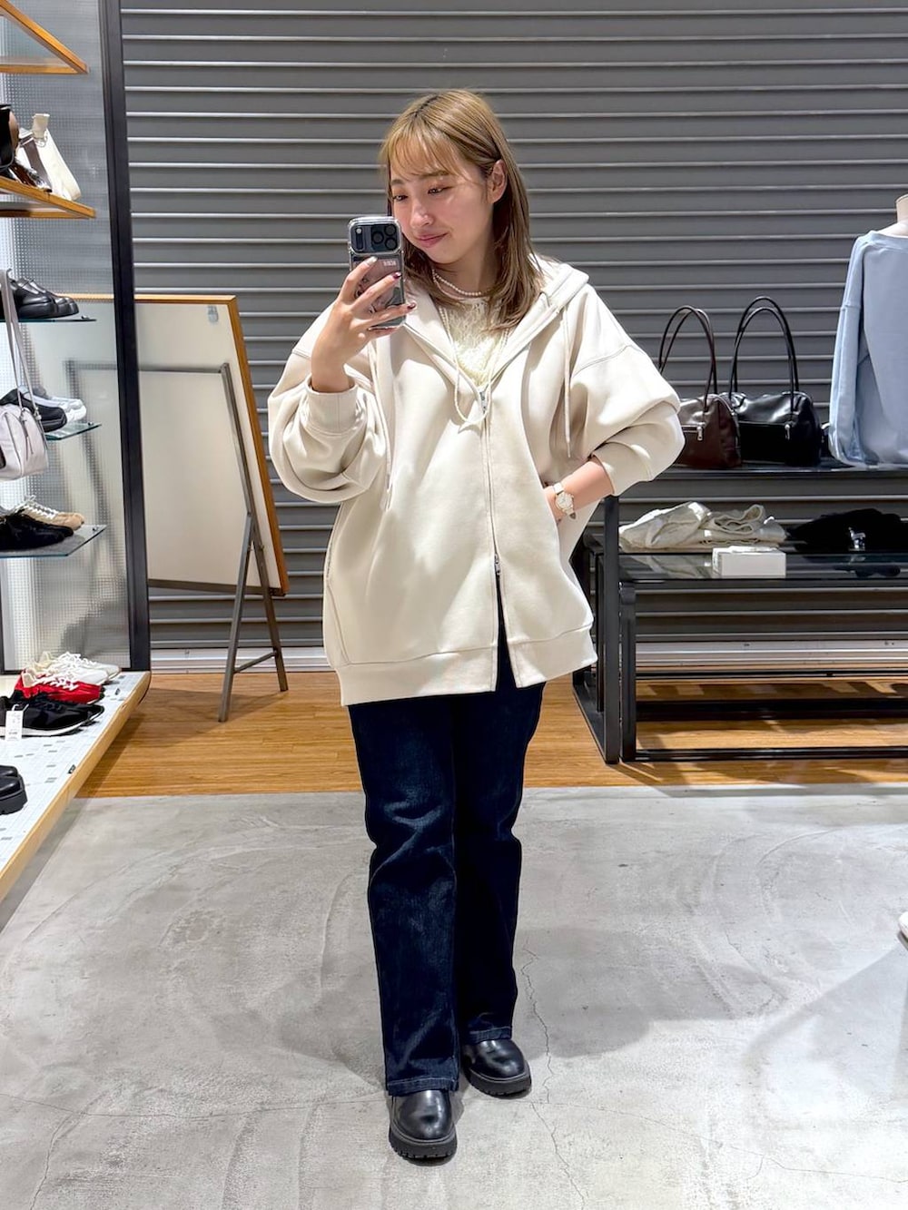 ホワイト系のパーカー、ブルー系のデニムパンツ、ホワイト系のTシャツ/カットソーを着用したレディースの春コーディネートの2枚目の写真