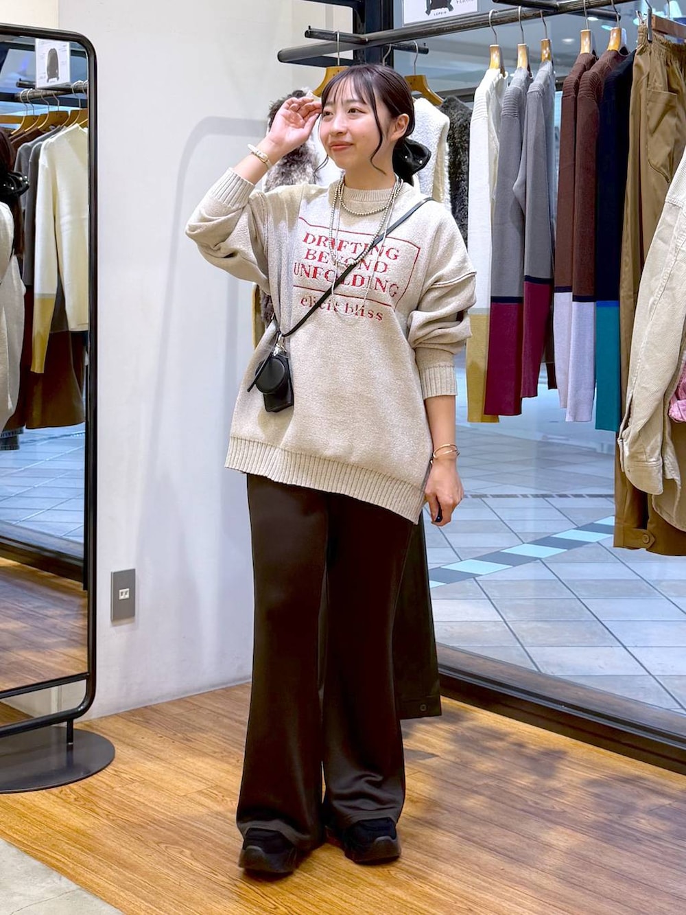 ブラック系のスニーカー、ブラック系のその他パンツ、ホワイト系のニット/セーターを着用したレディースの秋コーディネートの4枚目の写真