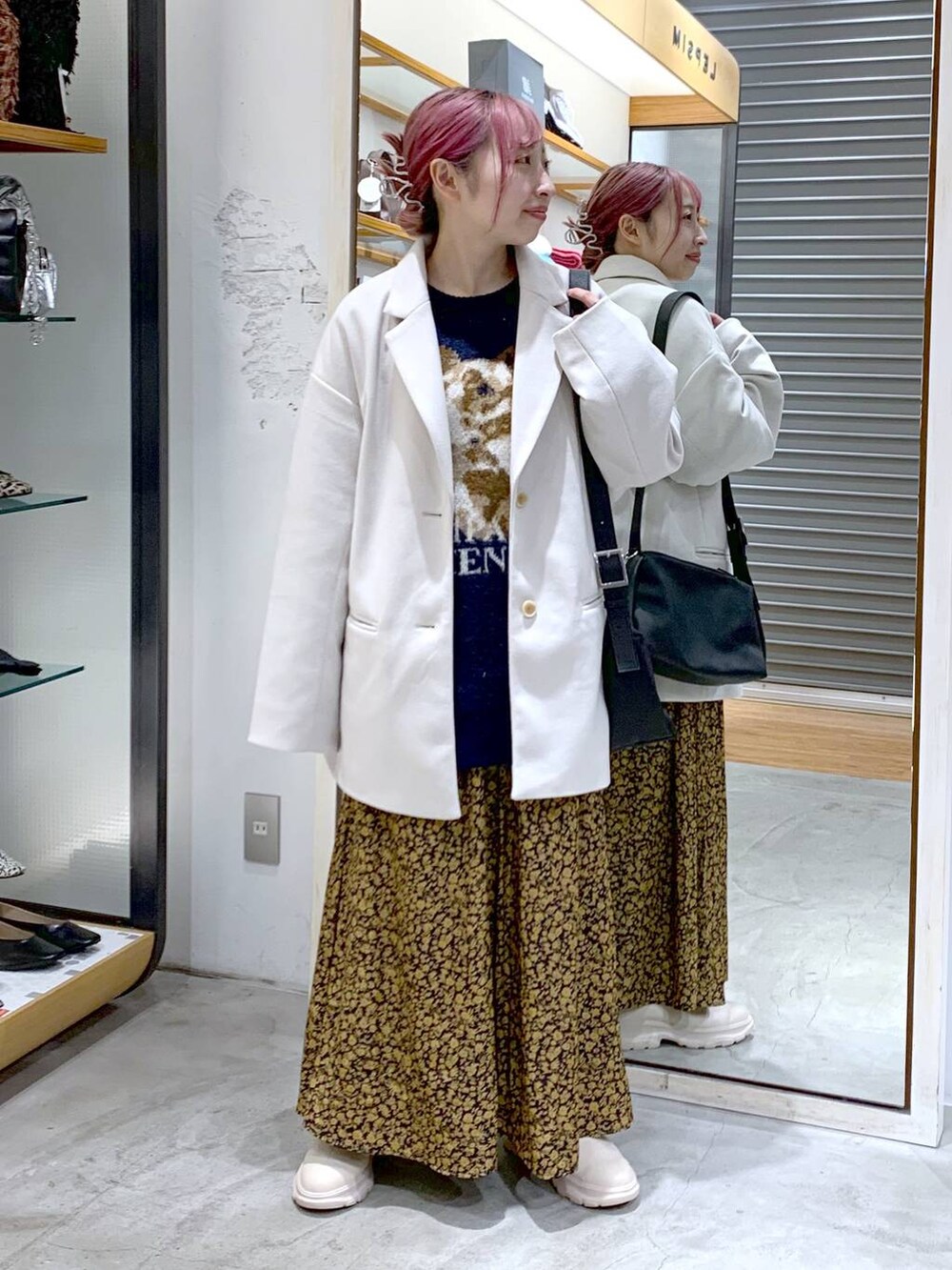 ホワイト系のその他アウター、ホワイト系のブーツ、ブラック系のショルダーバッグを着用したレディースの冬コーディネートの4枚目の写真