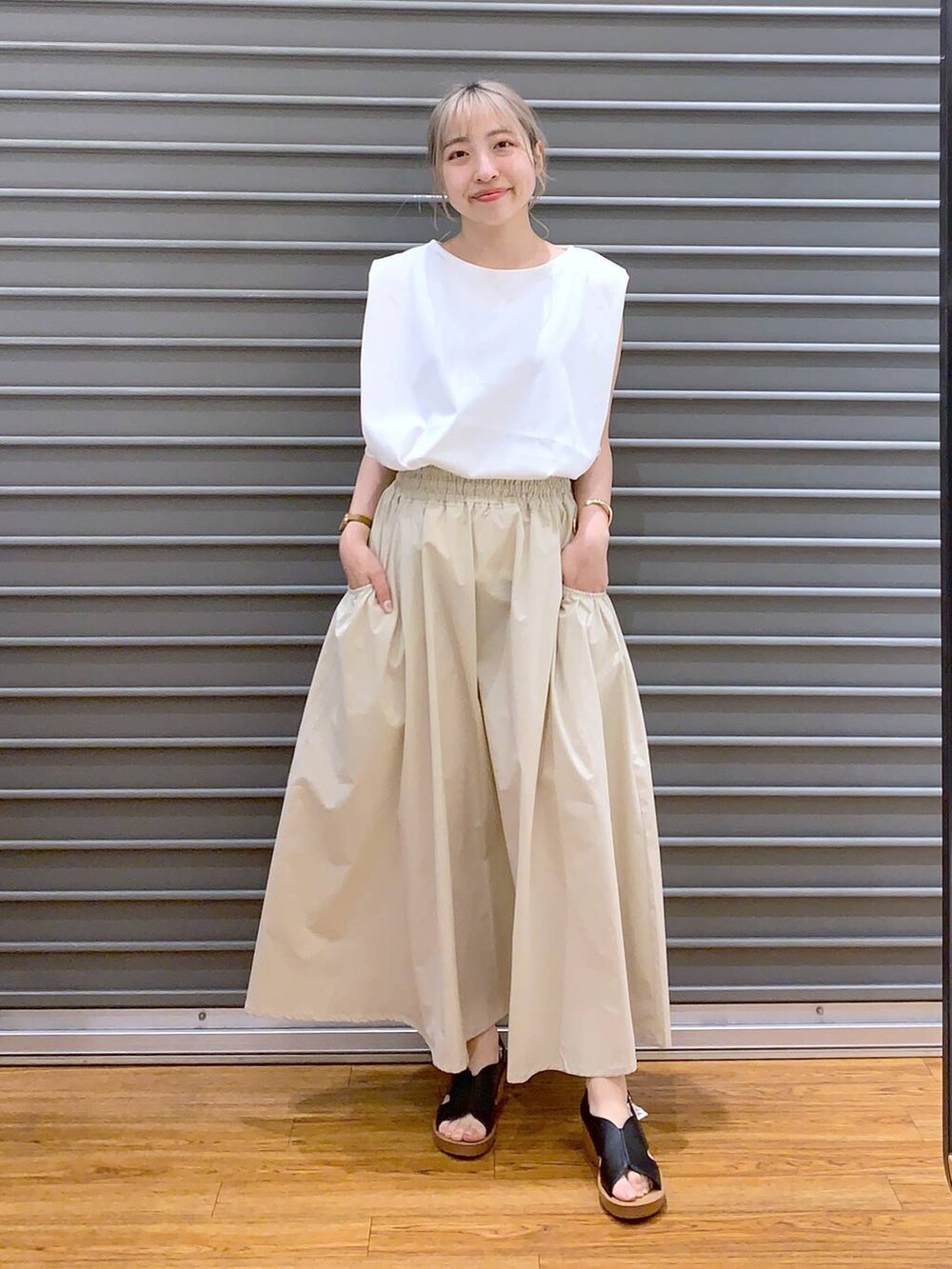 ブラック系のハンドバッグ、ホワイト系のスカート、ブラック系のサンダルを着用したレディースの夏コーディネートの4枚目の写真