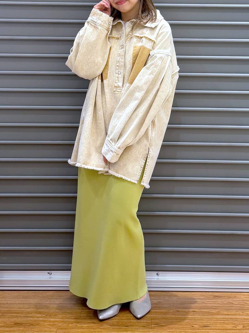 グリーン系のスカート、シルバー系のパンプス、ホワイト系のトートバッグを着用したレディースの春コーディネートの5枚目の写真