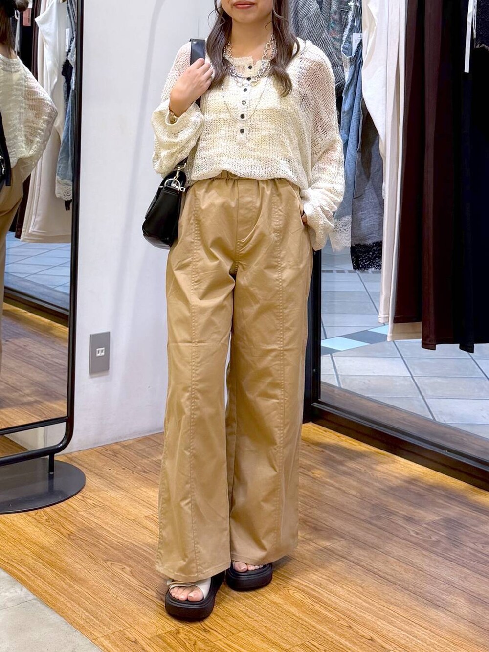 ベージュ系のその他パンツ、ホワイト系のニット/セーター、ブラック系のショルダーバッグを着用したレディースの秋コーディネートの5枚目の写真