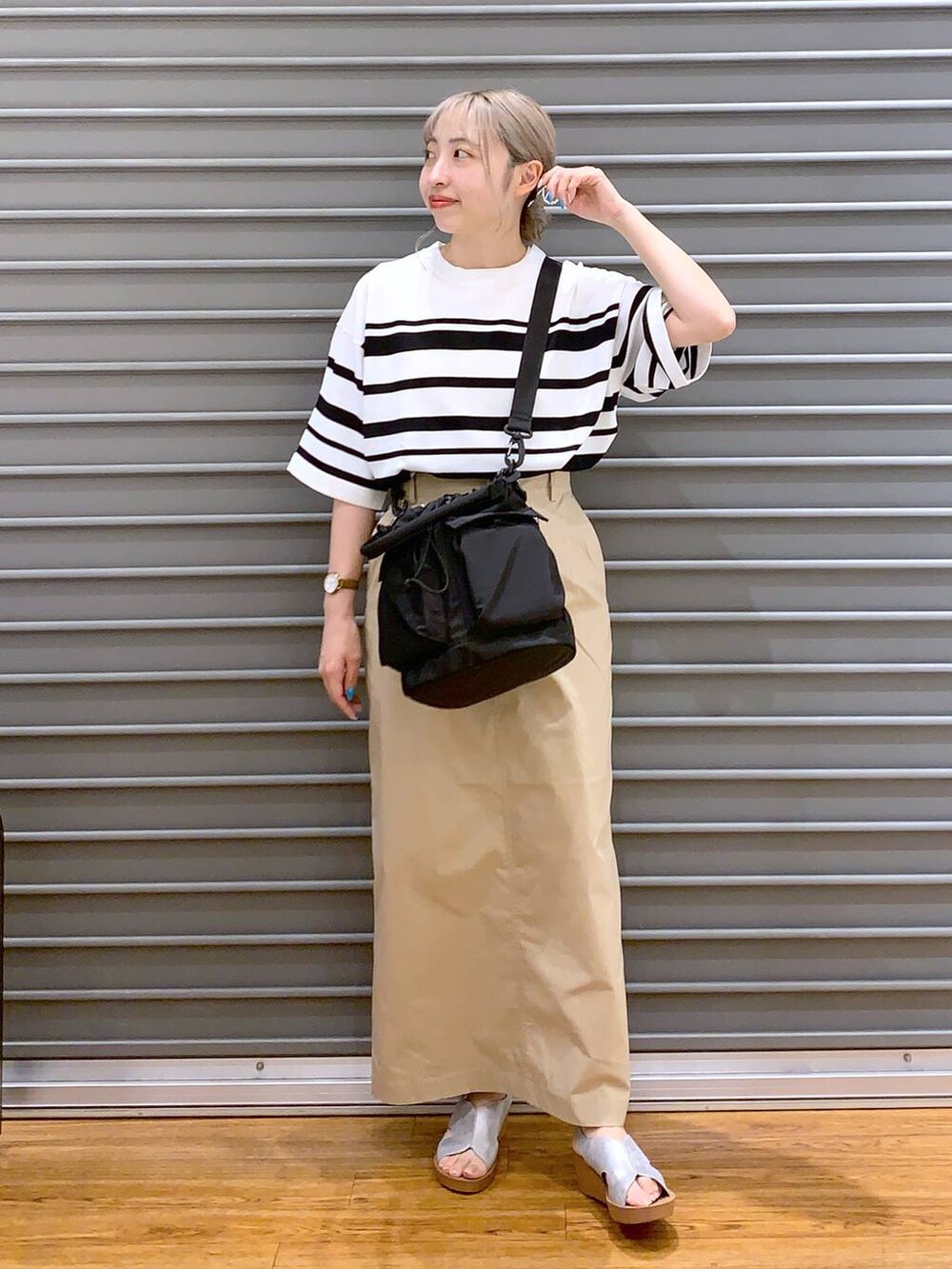 ベージュ系のスカート、シルバー系のサンダル、ホワイト系のニット/セーターを着用したレディースの夏コーディネートの3枚目の写真