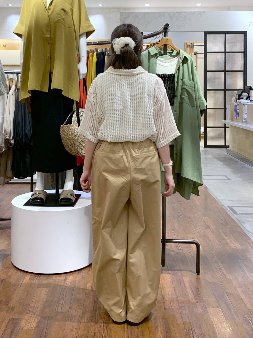 ホワイト系のサンダル、ベージュ系のその他パンツ、ブラック系のショルダーバッグを着用したレディースの夏コーディネートの2枚目の写真