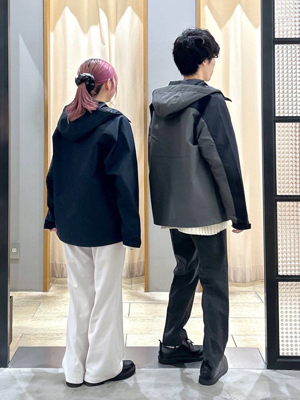 グレー系のスラックス、ブラック系のブーツ、ホワイト系のニット/セーターを着用したレディースの冬コーディネートの2枚目の写真