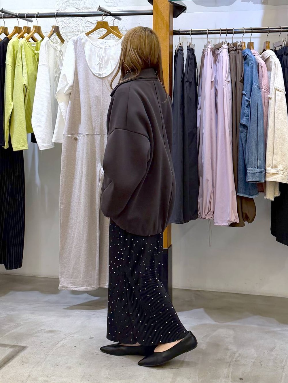 ブラック系のボストンバッグ、ブラック系のパンプス、グレー系のカーディガン/ボレロを着用したレディースの春コーディネートの3枚目の写真