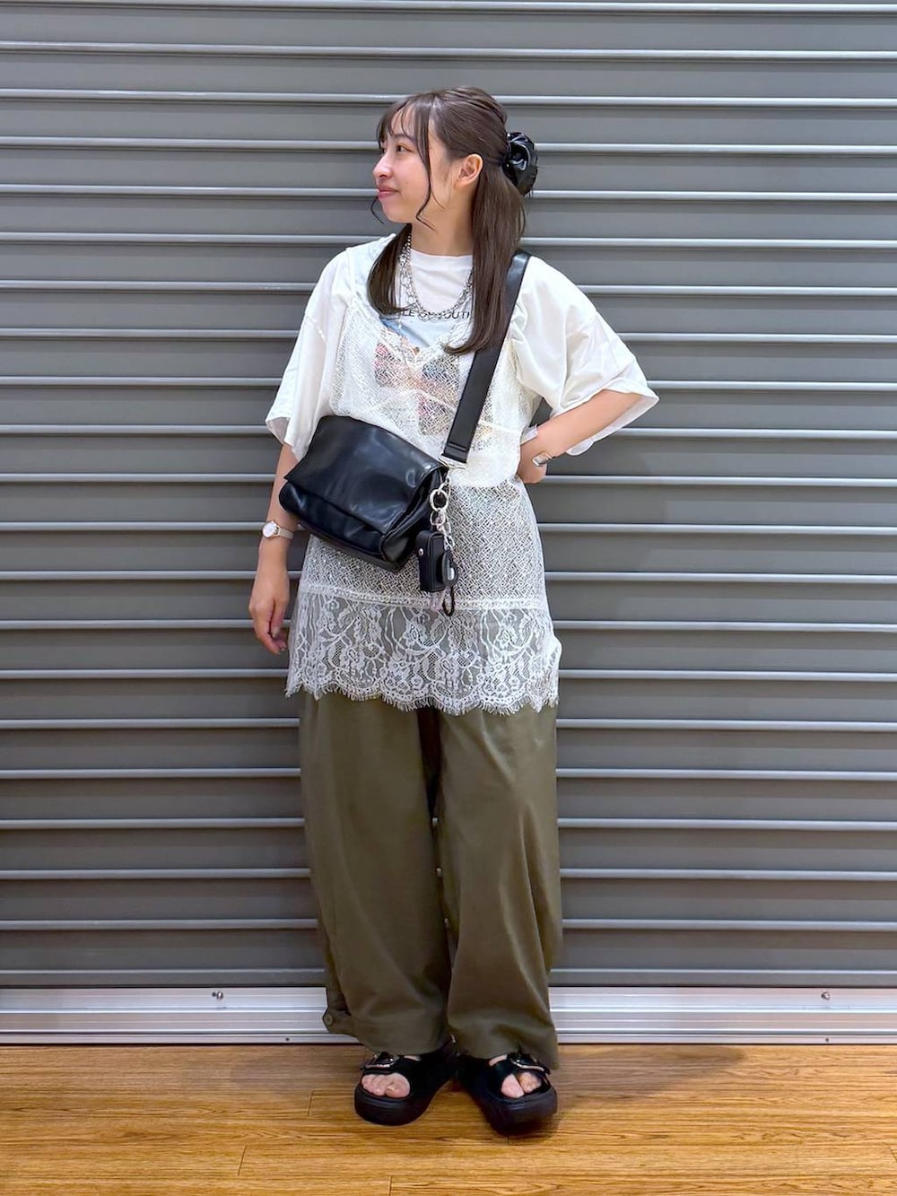 ホワイト系のTシャツ/カットソー、ブラック系のショルダーバッグ、ブラック系のサンダルを着用したレディースの夏コーディネートの4枚目の写真
