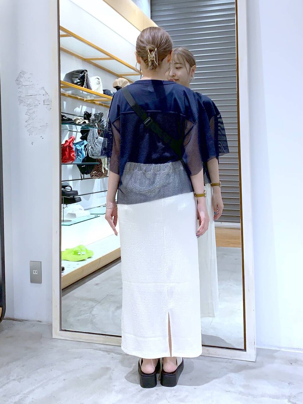 ブラック系のショルダーバッグ、ホワイト系のサンダル、ホワイト系のスカートを着用したレディースの夏コーディネートの2枚目の写真