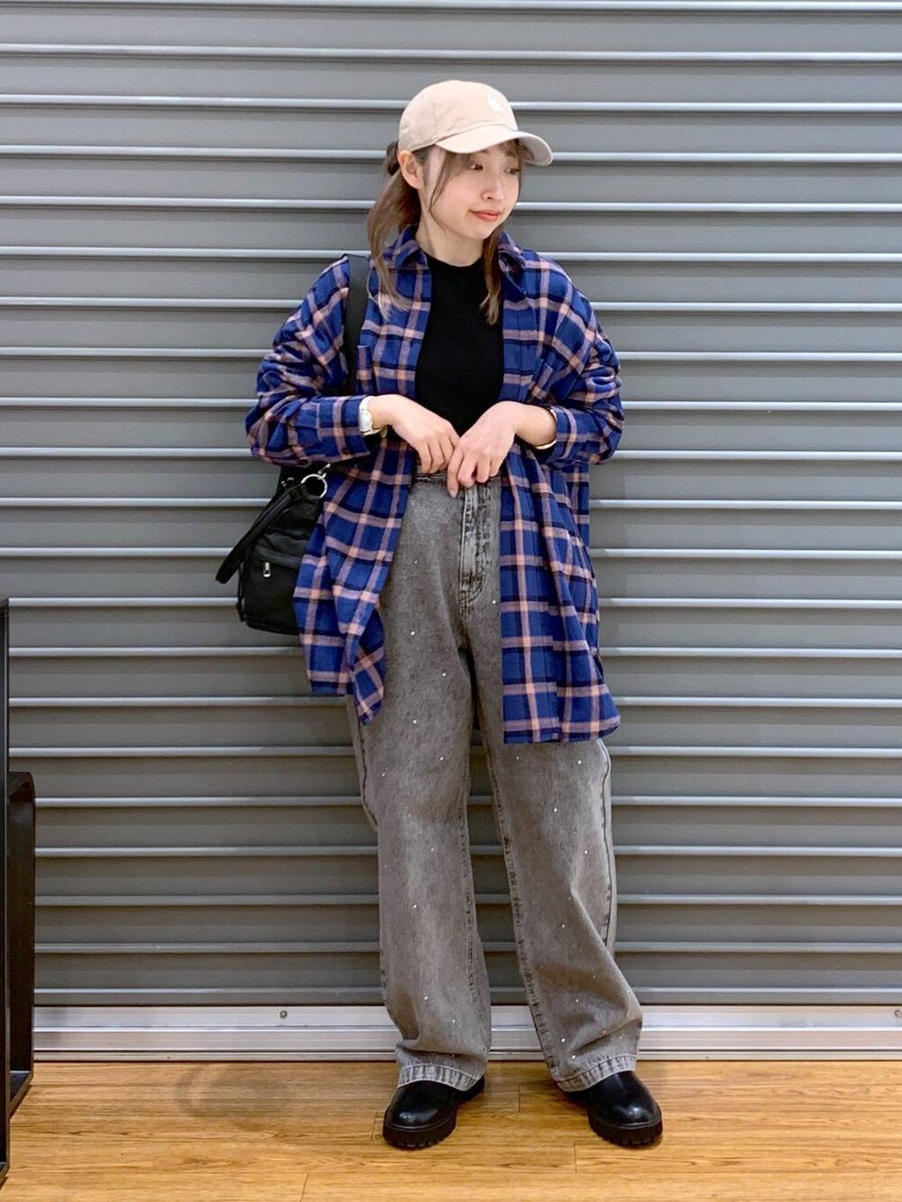 ブラック系のブーツ、ブラック系のニット/セーター、ブラック系のショルダーバッグを着用したレディースの冬コーディネートの3枚目の写真