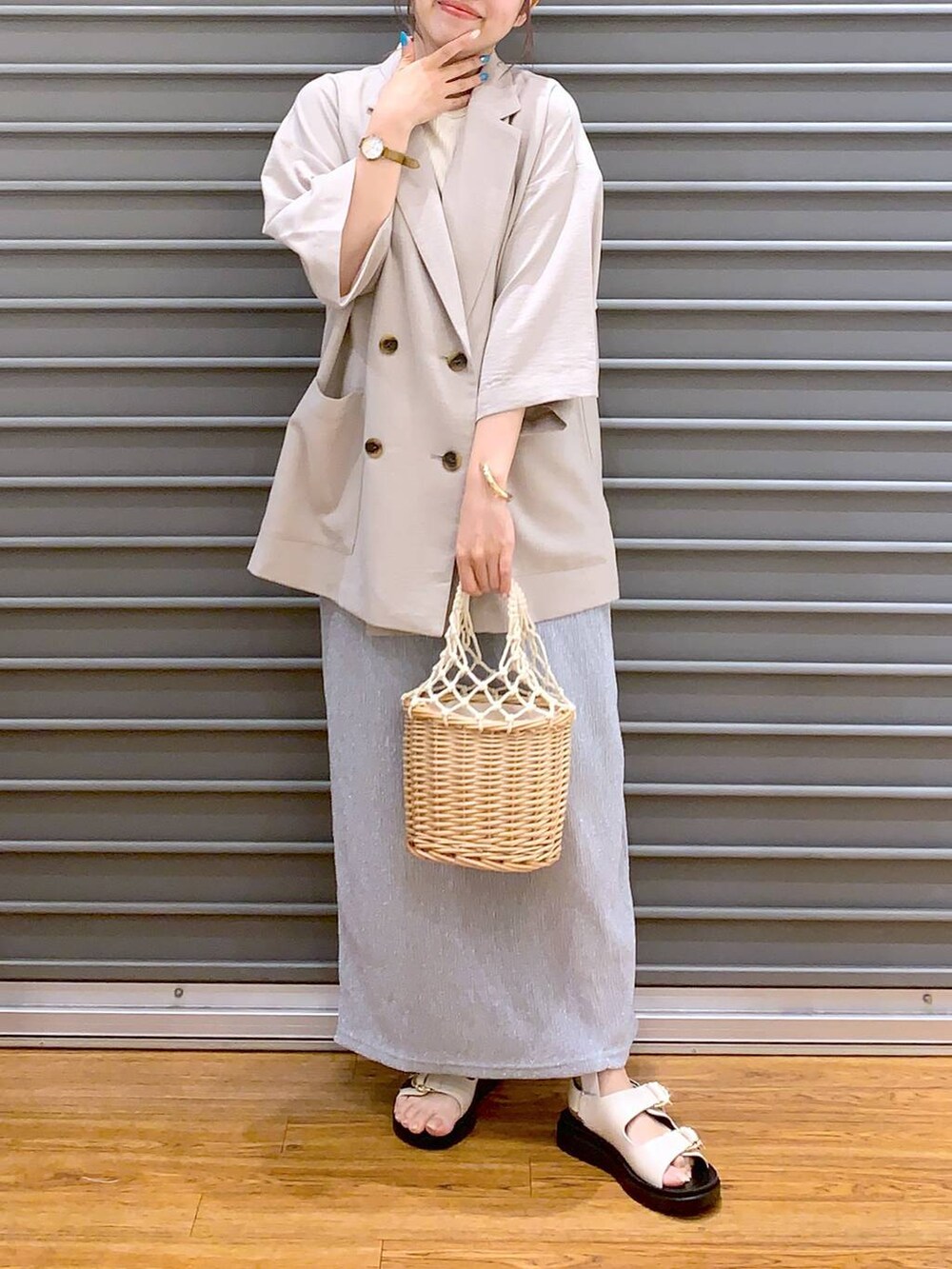 ベージュ系のテーラードジャケット、ホワイト系のサンダル、グレー系のスカートを着用したレディースの夏コーディネートの5枚目の写真